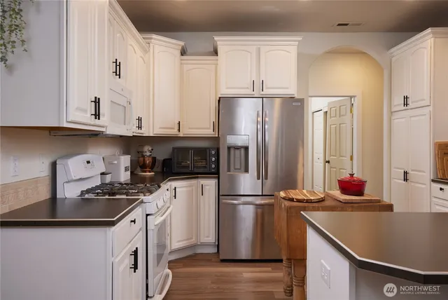 a bedroom with a bed and a flat tv screen on dresser