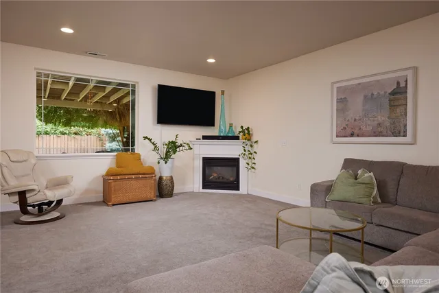 a living room with furniture a flat screen tv and a fireplace