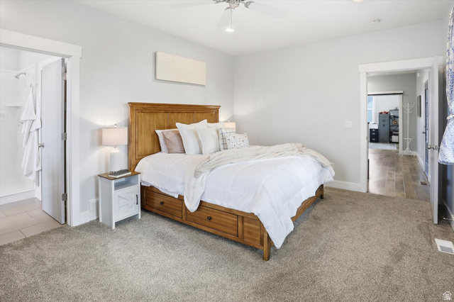 1009 High Creek Road Cove, UT 84320 - Photo 28 of 79 main floor primary Bedroom with light carpet, ceiling fan, and connected bathroom