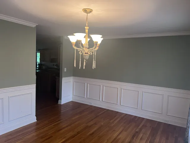 a view of a hallway with wooden floor and windows