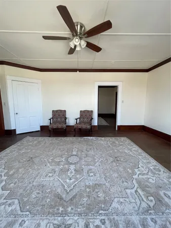 a living room with couches and ceiling fan