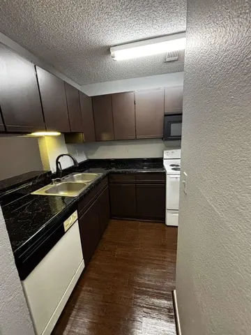 a kitchen with stainless steel appliances granite countertop a stove a sink and a microwave