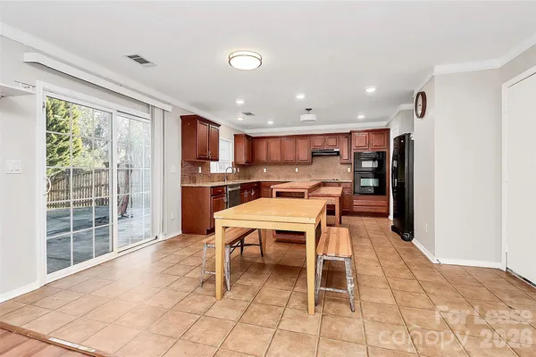 a open kitchen with stainless steel appliances kitchen island granite countertop a refrigerator and a sink