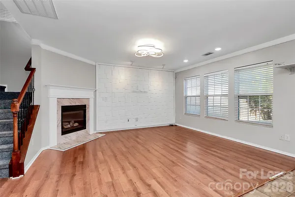 a view of an empty room with a fireplace and a window