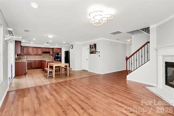 a living room with stainless steel appliances kitchen island a table and chairs