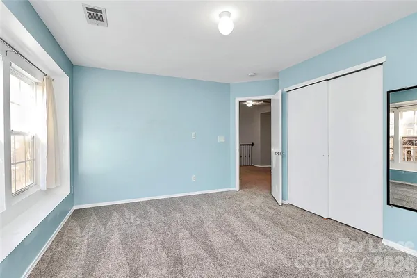an empty room with windows and closet