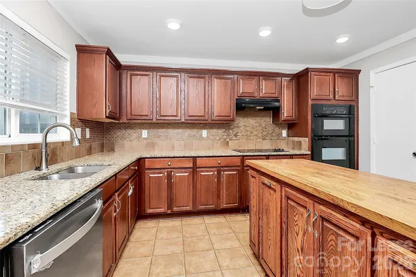 a kitchen with stainless steel appliances granite countertop a sink stove and cabinets