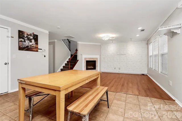 a view of an empty room with wooden floor fireplace and a window