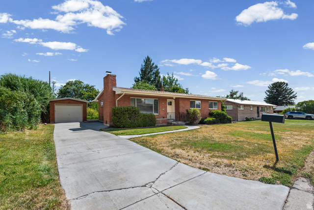 542 East 3400th Street North Provo, UT 84604 - Photo 2 of 39 Brick ranch-style home featuring a paved driveway, detached garage, and mature shrubbery