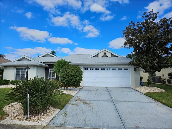 a view of a house with a yard and potted plants