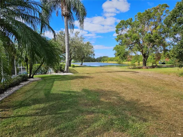 a view of a field with trees in the background