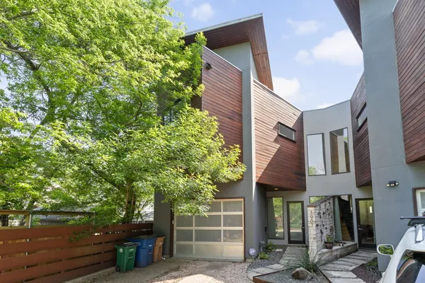 a front view of a house with a tree