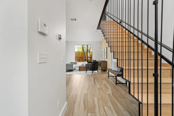 a view of a hallway with wooden floor and staircase