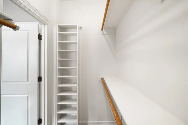 a view of closet with wooden floor