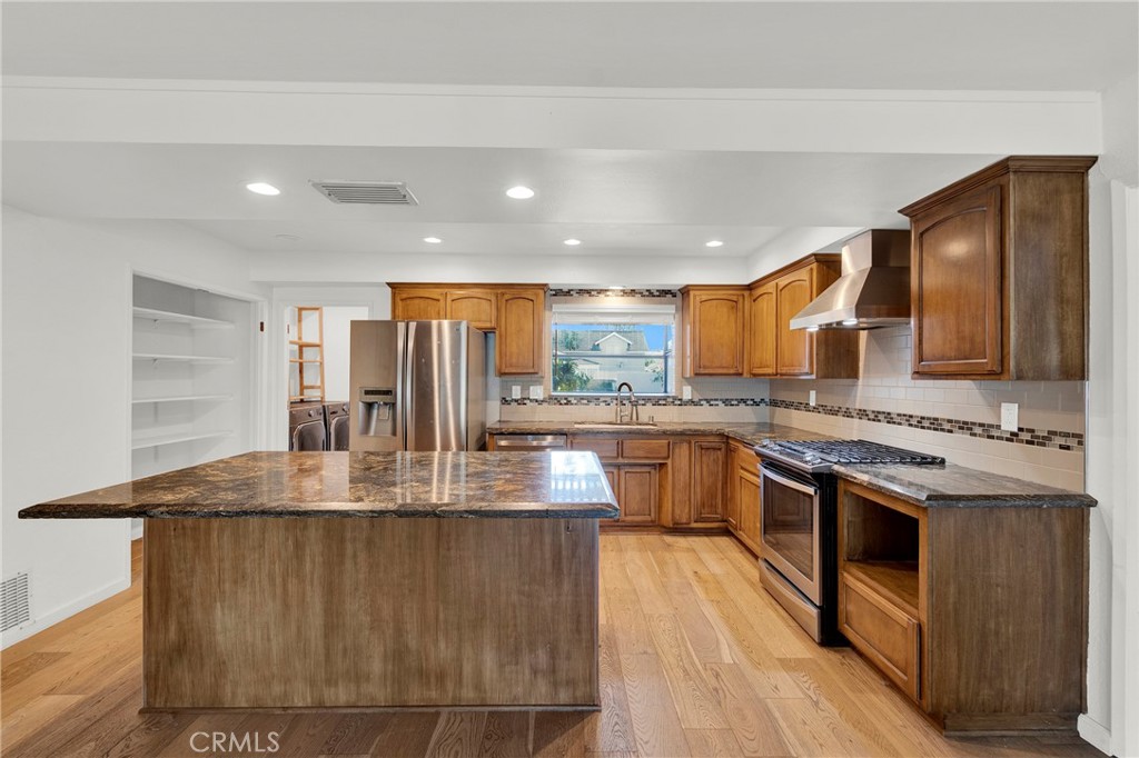 13381 Epping Way Tustin, CA 92780 - Photo 13 of 52 a large kitchen with stainless steel appliances granite countertop a lot of counter space and a sink