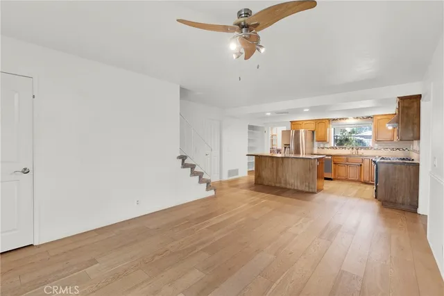 a view of a kitchen with a sink a ceiling fan and wooden floor