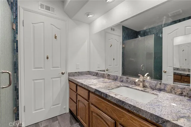 a bathroom with a granite countertop sink and a mirror