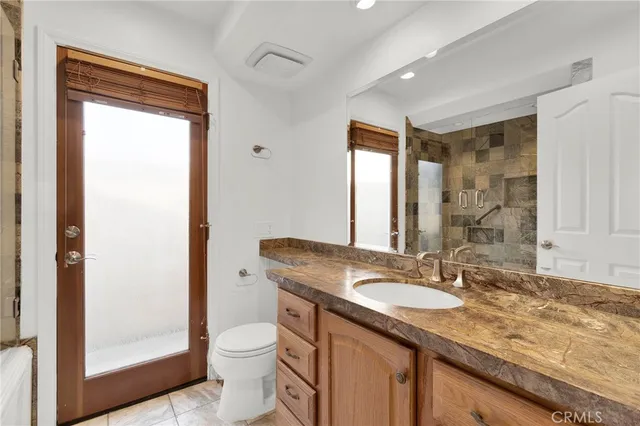a bathroom with a granite countertop sink toilet and shower