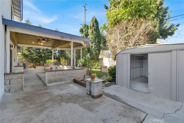 a view of a house with a small yard and potted plants