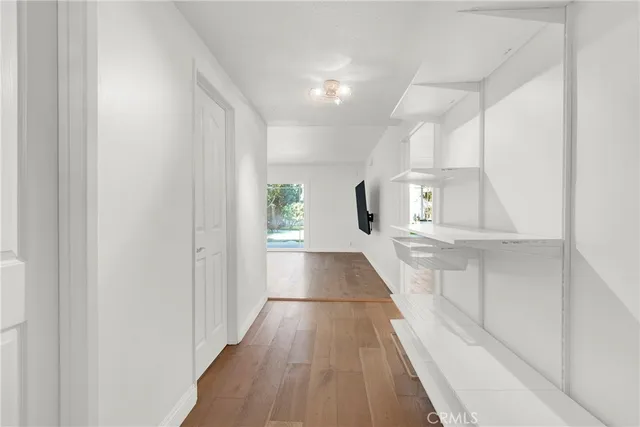 a view of a hallway with wooden floor