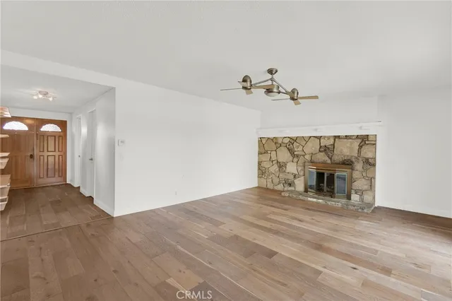 a view of an empty room with a fireplace and a window