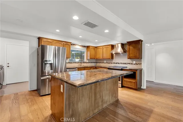 a kitchen with stainless steel appliances granite countertop a sink and a refrigerator