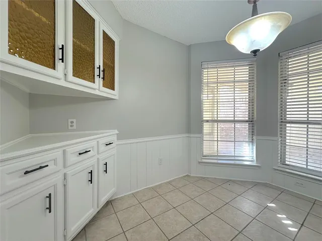 a kitchen with white cabinets and white appliances
