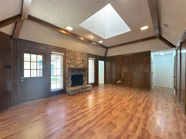 a view of an empty room with a fireplace and a window