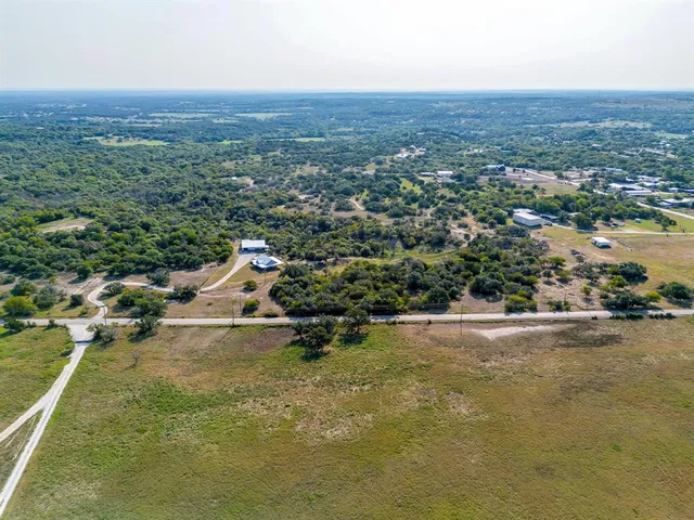 an aerial view of a houses with a yard and lake view