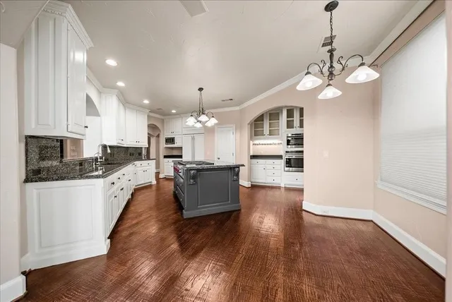 a kitchen with stainless steel appliances granite countertop a stove and a white cabinets