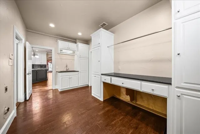 a view of an empty room with wooden floor and windows