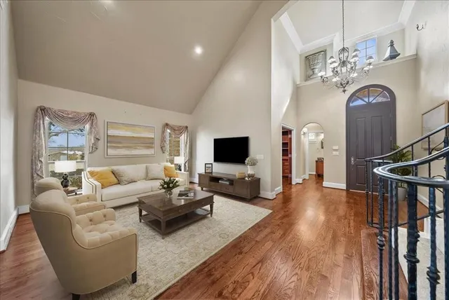 a open kitchen with granite countertop a stove top oven a sink dishwasher and white cabinets with wooden floor