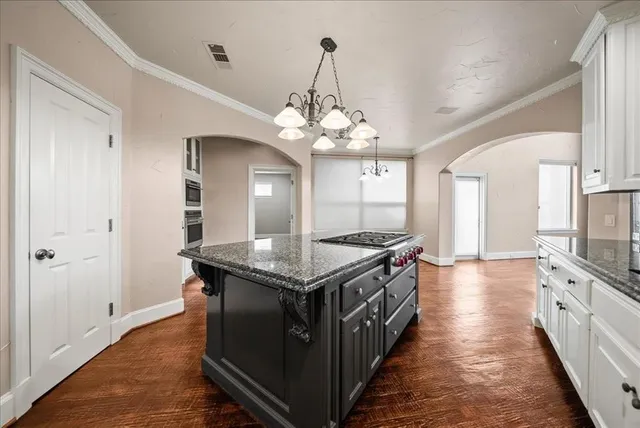 a kitchen with stainless steel appliances white cabinets and stove