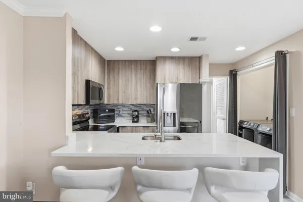 a dining room with stainless steel appliances a dining table and chairs