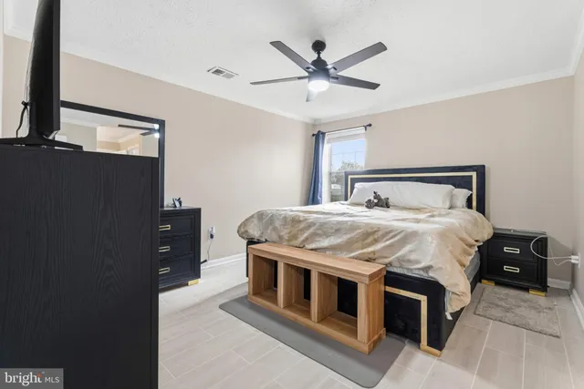 a bedroom with a large bed and a flat tv screen on dresser