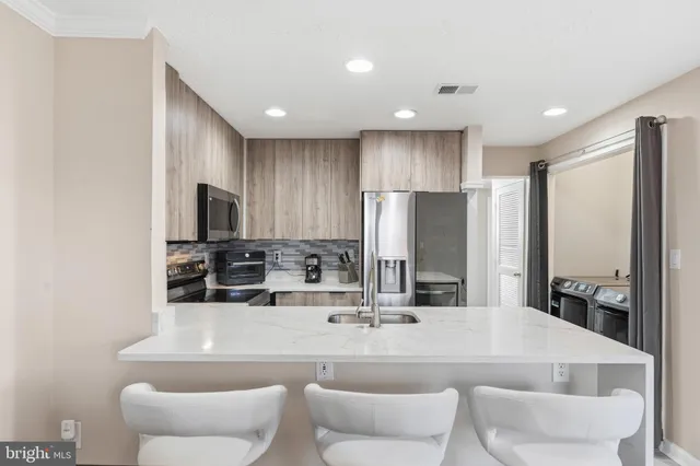 a dining room with stainless steel appliances a dining table and chairs