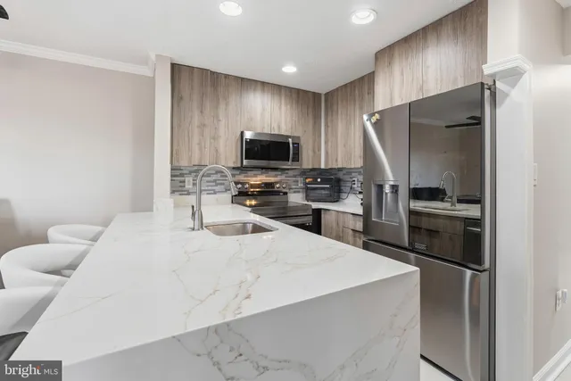 a kitchen with a refrigerator a microwave a sink and cabinets
