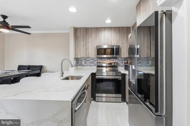 a kitchen with stainless steel appliances a stove microwave and sink