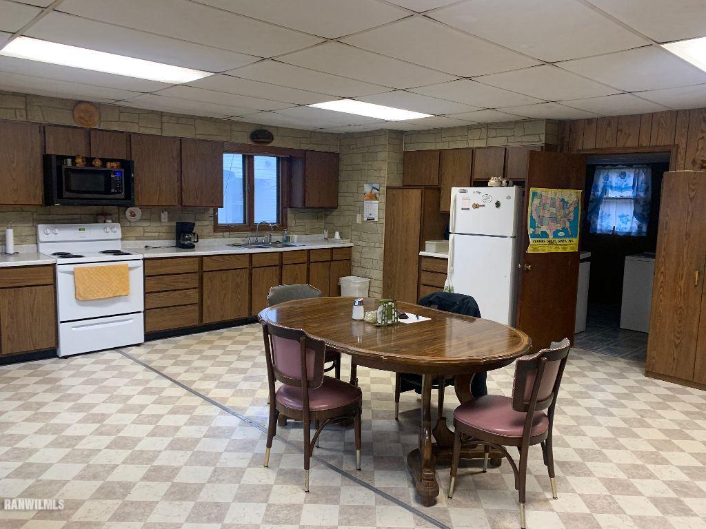 2708 West Florence Road Freeport, IL 61032 - Photo 7 of 16 a kitchen with stainless steel appliances granite countertop a table chairs refrigerator and microwave