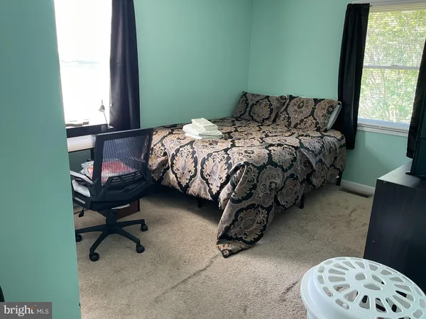 a bed sitting in a bedroom next to a window