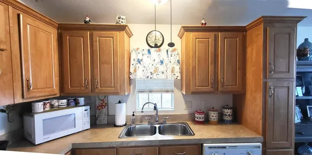 a kitchen with stainless steel appliances granite countertop a sink a stove and a window