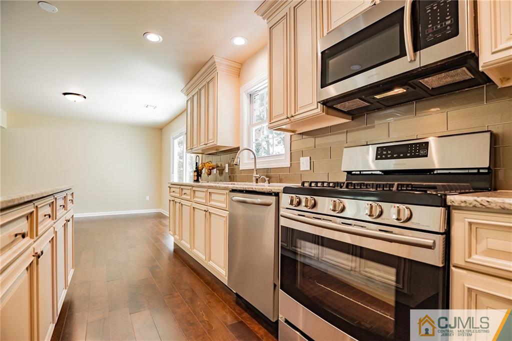 8 Dayton Road Edison, NJ 08817 - Photo 8 of 25 a kitchen with stainless steel appliances granite countertop a stove a sink and a microwave
