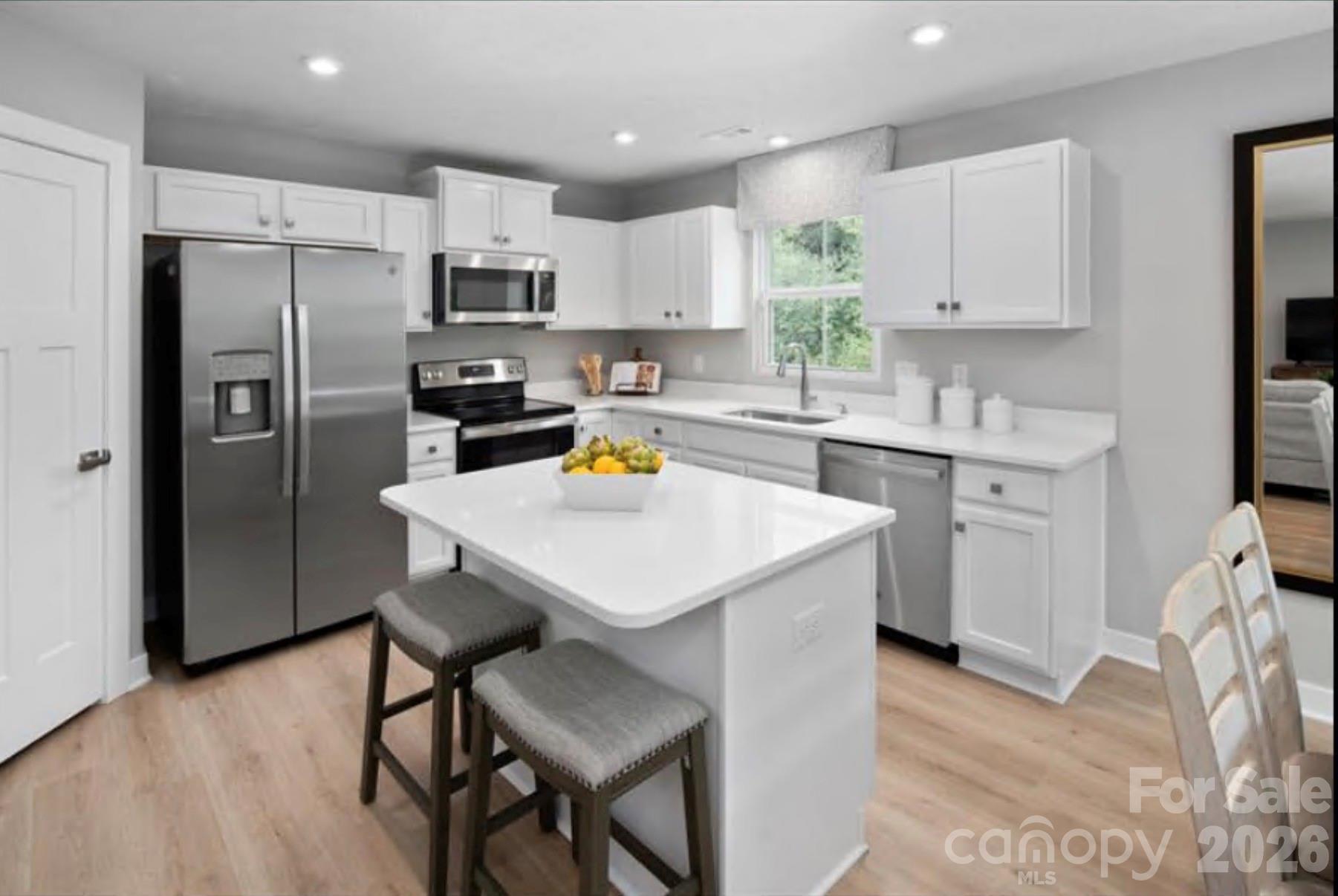 609 Nesbe Street Lancaster, SC 29720 - Photo 3 of 13 a kitchen with a sink a refrigerator and white cabinets