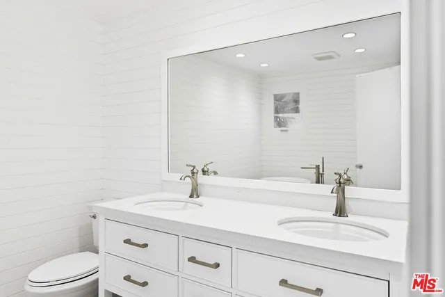 a bathroom with a sink a toilet and a mirror