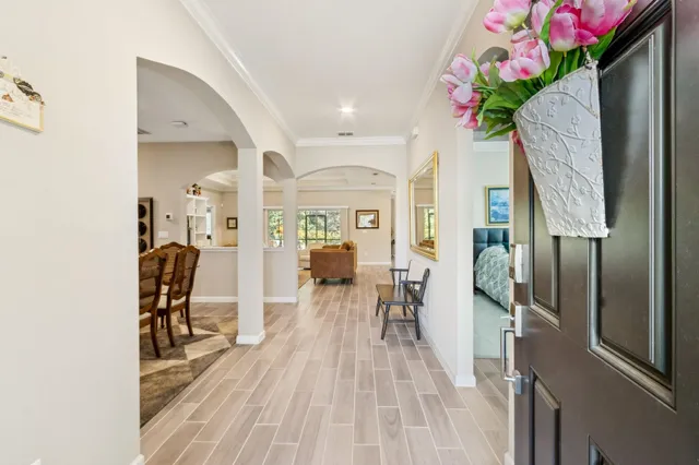 a open kitchen with stainless steel appliances granite countertop a stove top oven a sink dishwasher a dining table and chairs with wooden floor