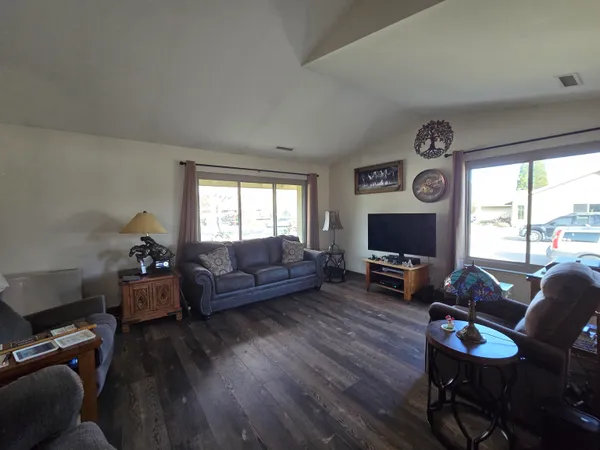 a living room with furniture a flat screen tv and a large window