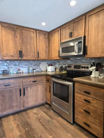 a kitchen with stainless steel appliances granite countertop a stove a sink and a microwave