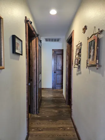 a view of a hallway with wooden floor and windows