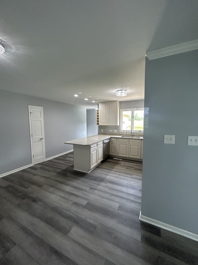 32-w320 Montgomery Road Aurora, IL 60504 - Photo 12 of 37 a view of kitchen and empty room with wooden floor