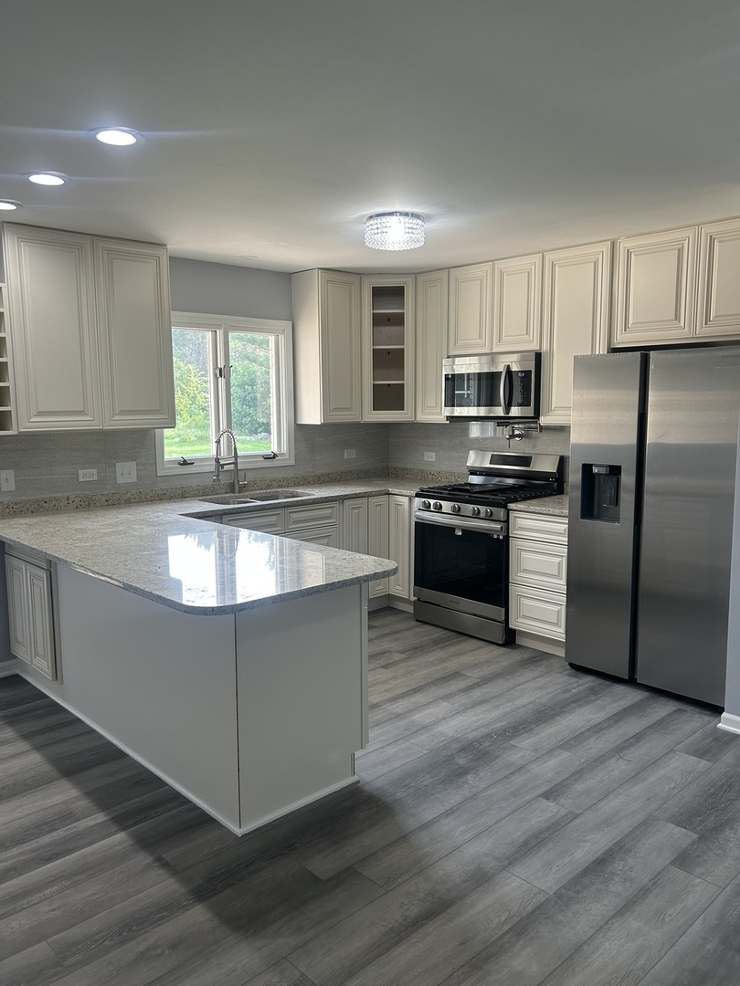 32-w320 Montgomery Road Aurora, IL 60504 - Photo 13 of 37 a kitchen with stainless steel appliances granite countertop a refrigerator a sink a stove a microwave and wooden cabinets